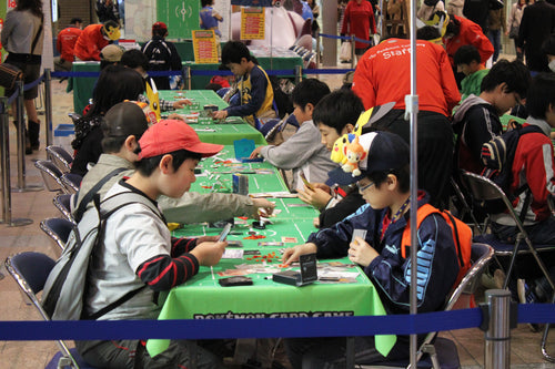 Players taking part in a Pokémon Trading Card Game match; licensed CC BY 2.0 via Wikimedia Commons.